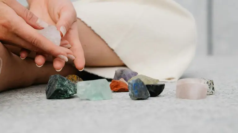 Sieviete meditē blakus ginella dabīgajiem akmeņiem