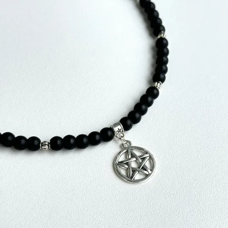 Tuvplāns ar Ginella Oniksa un pentagrammas kaklarota "Rituāls" uz gaiša fona
