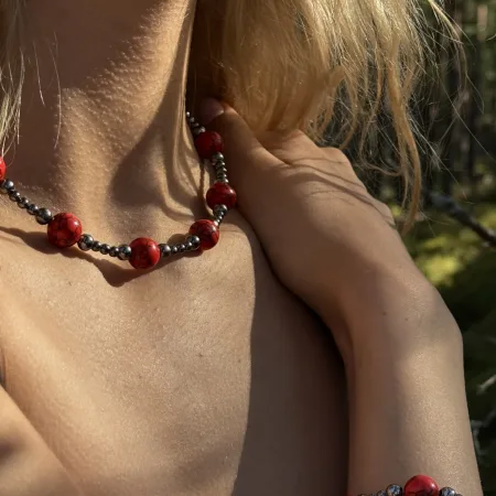 ginella modele ar sarkanās jašmas rotu komplekts "Sarkanā gaisma" pozē mežā
