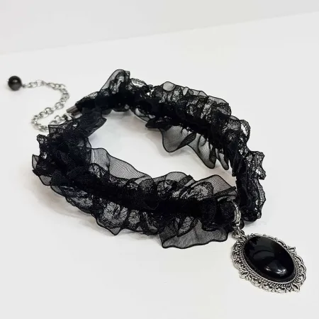 Ginella kaklarota no melnā obsidiāna "melnā orhideja" uz gaišas virsmas
