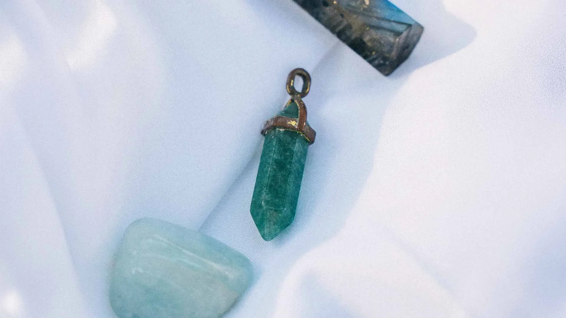 akvamarīns dabīgais akmens talismans no Ginella uz gaiša palaga